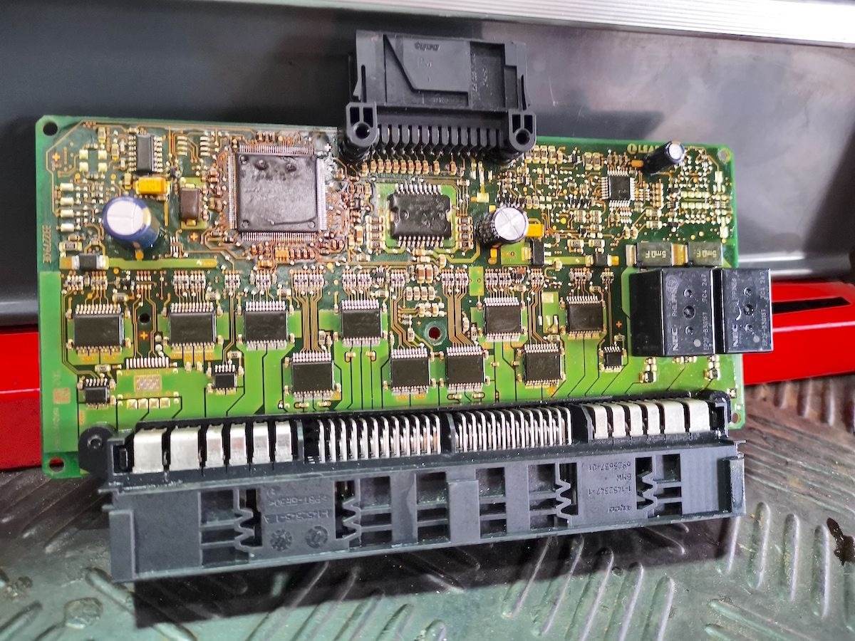 BMW FRM3 footwell module circuit board opened for repair, showing the processor and output stages